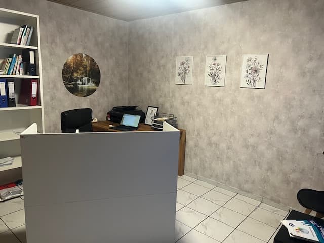 Empfangsbereich der Naturheilpraxis mit Arbeitsplatz und Fachbüchern